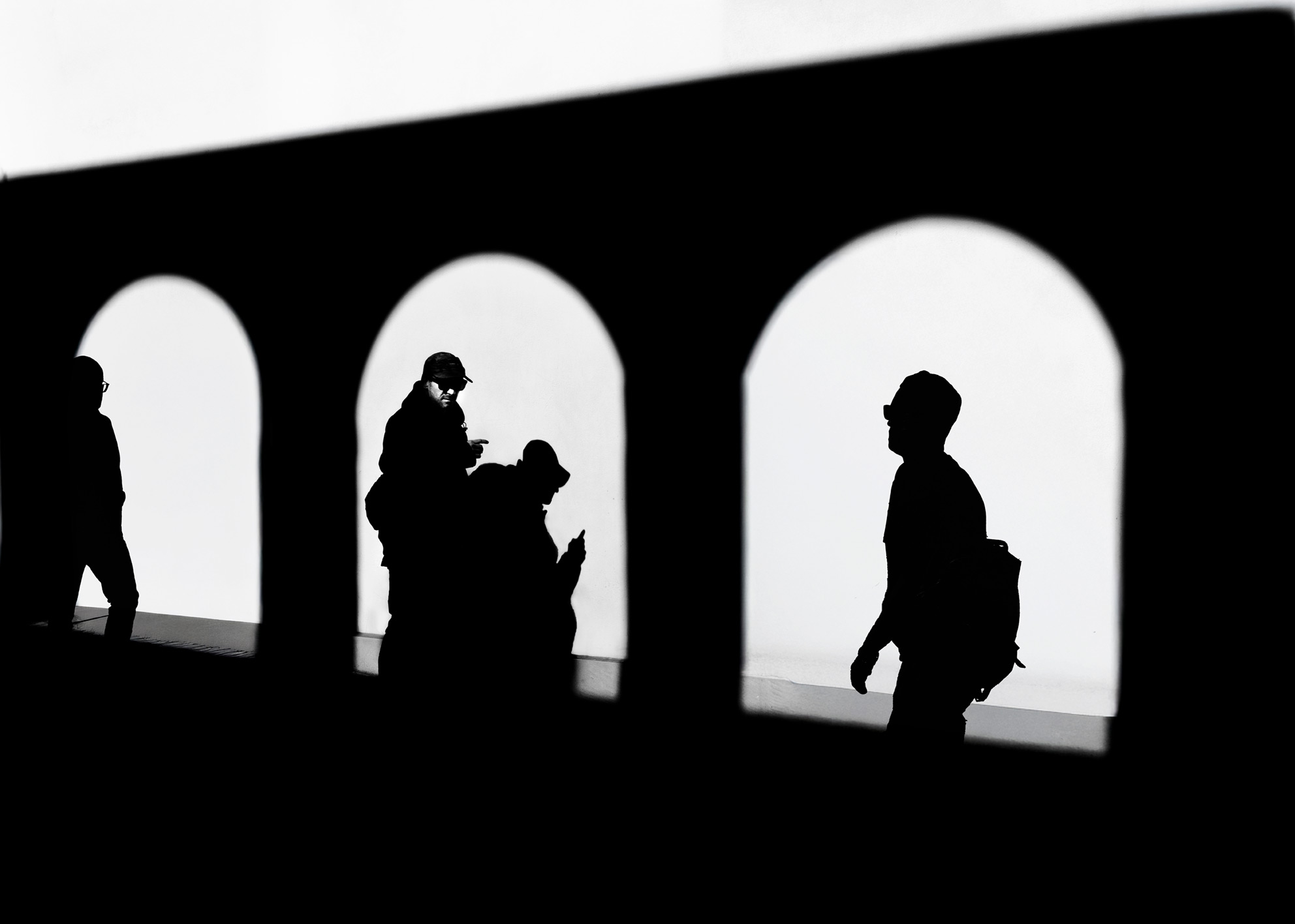 Fotografia street archi romanici trittico silhouette multiple architettura italiana geometria narrativa bianco nero. Street photography romanesque arches triptych multiple silhouettes italian architecture geometry narrative black white museum art