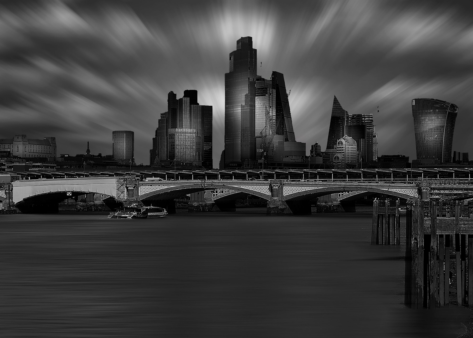 Skyline urbano con ponte sul fiume e grattacieli moderni riflessi sull’acqua in atmosfera drammatica Urban skyline with bridge over the river and modern skyscrapers reflected on water in dramatic atmosphere